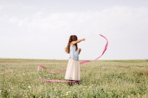 ragazza-che-balla-con-il-nastro-relativo-alla-ginnastica-nel-campo_23-2147711489